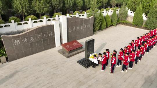 学生们向无名烈士墓碑敬献花朵和擦拭碑刻