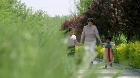 阳光下妈妈带着两个孩子走路奔跑视频素材模板下载