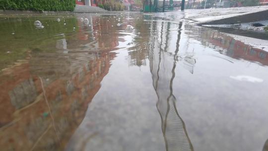 下雨天雨点滴落到水洼中