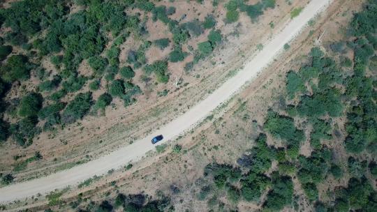 空中跟踪拍摄的吉普车行驶在非洲偏远荒地的土路上