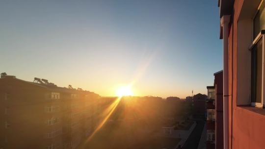 【延时】春天里清晨的霞光洒向窗外的城市视频素材模板下载