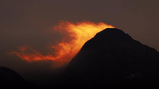 夕阳下山脉山峰云雾飘动逆光剪影