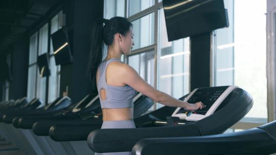穿运动内衣的年轻女性在健身房使用跑步机视频素材模板下载