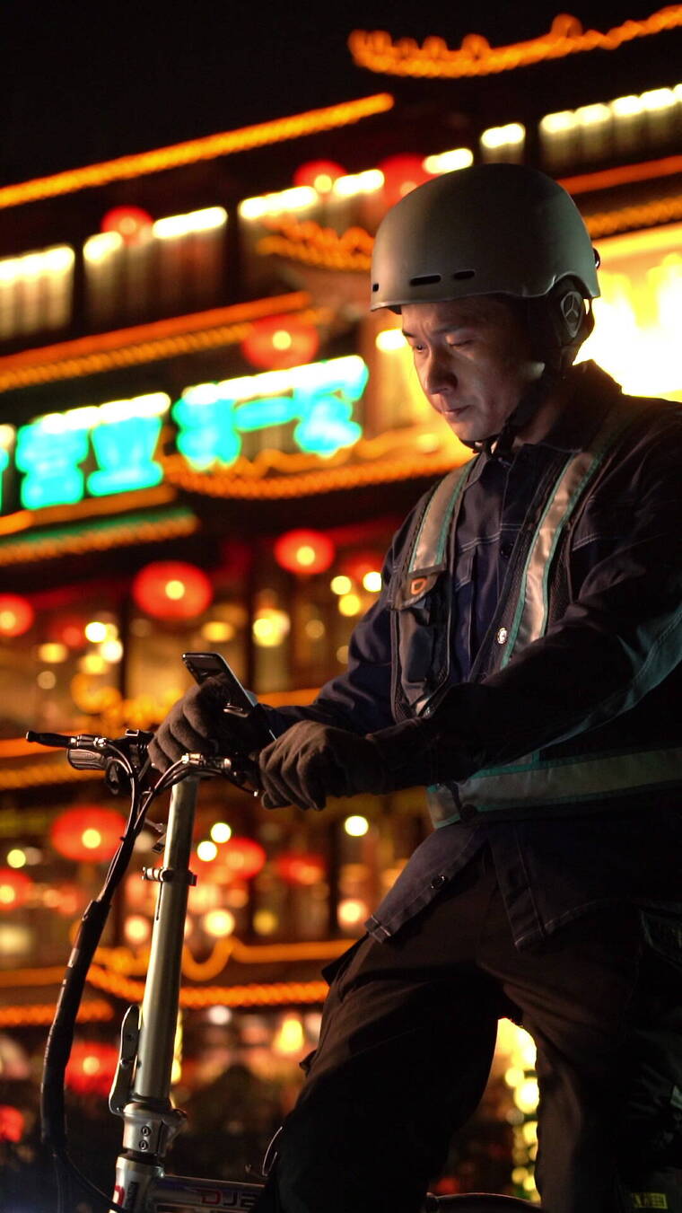 在路边等待订单信息的青年代驾司机