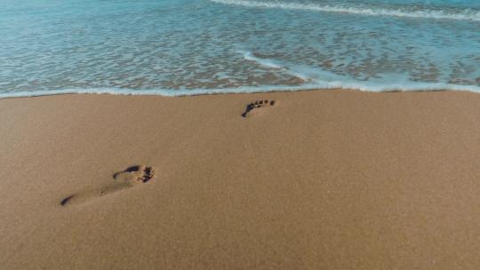 海浪冲刷沙滩上的脚印