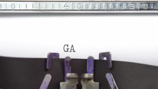 游戏结束短语特写正在打字并集中在老式打字机上的一张纸上