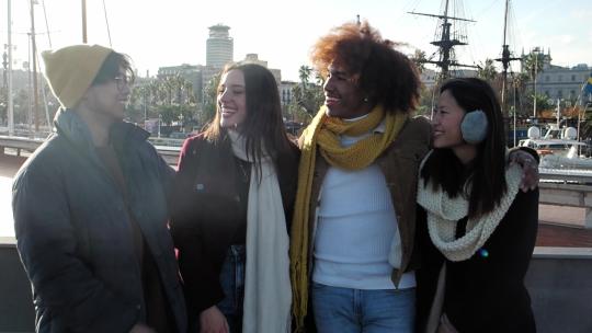 一群穿着冬装的多民族年轻人在一个城市里互相交谈