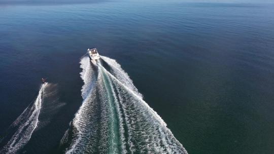 带滑水板骑手的快艇进入大海的俯视图