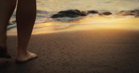 女孩光脚走在沙滩上