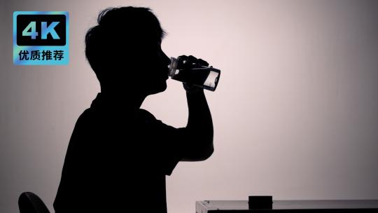 男人喝水剪影水杯喝水水杯拧紧杯盖视频素材模板下载