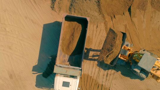挖掘机将沙子运入卡车