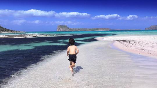 男孩在海滩的水中奔跑视频素材模板下载