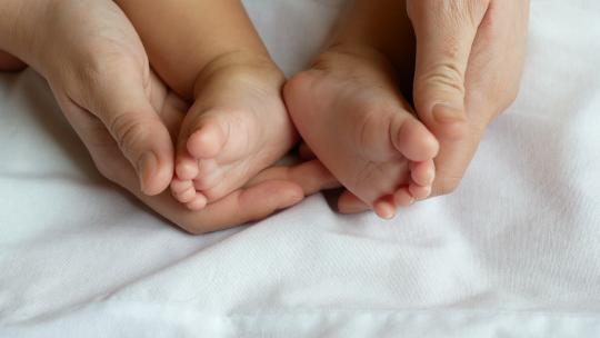 母亲的手抚摸着婴儿的脚视频素材模板下载