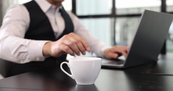一个商务男士坐在会议室办公喝咖啡