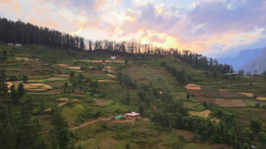 无人机拍摄卡索尔马纳利附近喜马偕尔邦塞恩吉山谷一个小村庄的日落