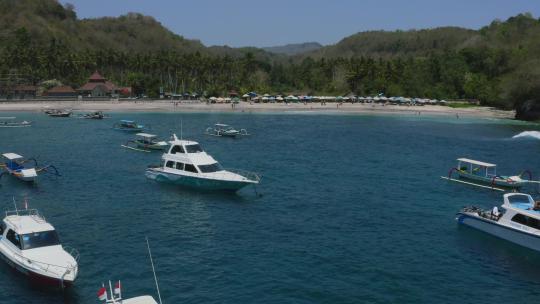 停泊在水晶湾白色沙滩附近蓝色热带海洋中的船只nusa penida bali，空中