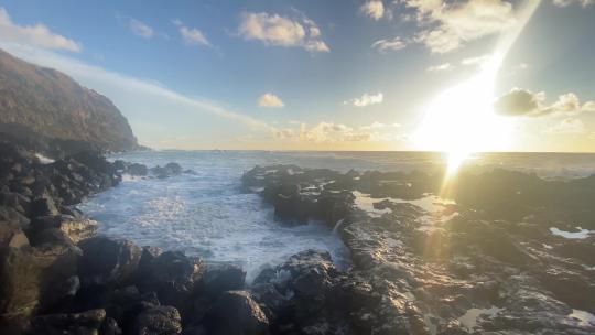 朝阳日出海浪拍打着岩石海岸