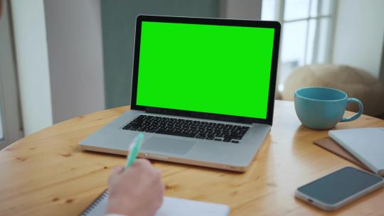 办公室人员使用带绿幕的笔记本电脑