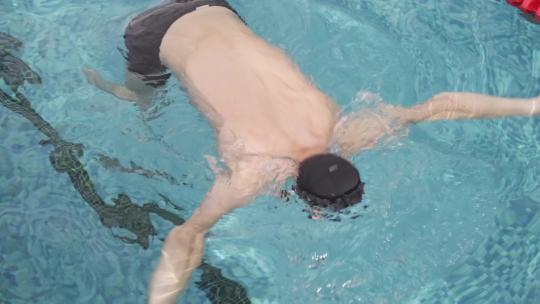 腿部残疾的人在游泳池练习游泳