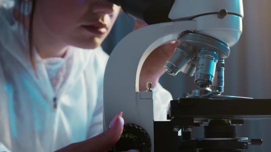 科学家使用显微镜研究药品病毒
