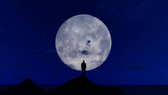 站山顶仰望月亮变化的人