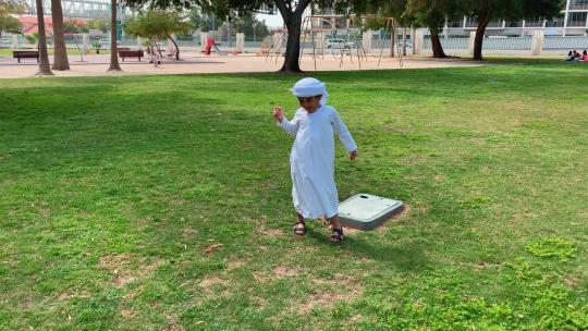 阿拉伯阿联酋男孩穿着Kandura盘破折号踢足球。阿拉伯孩子白天打球视频素材模板下载