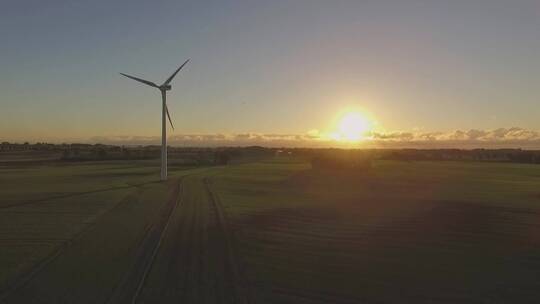 日出时田野上的风力涡轮机风车航拍