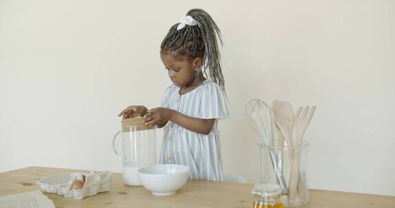 一个小女孩把牛奶倒在碗里