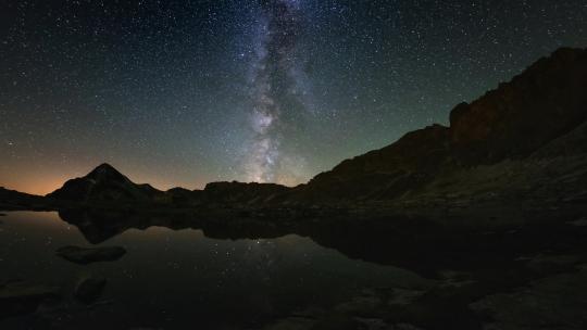 银河系的时间流逝和夏季夜空中的星星在阿尔卑斯山上空旋转