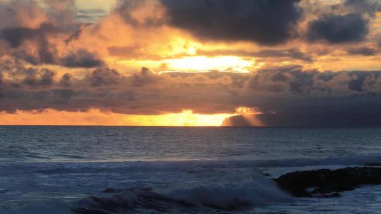 清晨海边日出海浪翻滚大海阳光光线穿过云层