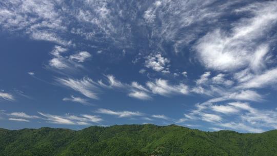 蓝天中森林山脊上的部分卷云