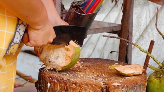 村街子地摊椰子小贩剥椰子皮露出白色椰肉