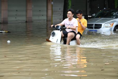 广西南宁暴雨内涝多车被泡民众深水中骑行