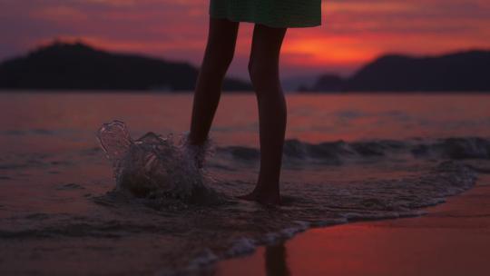 女孩在日落海滩边行走
