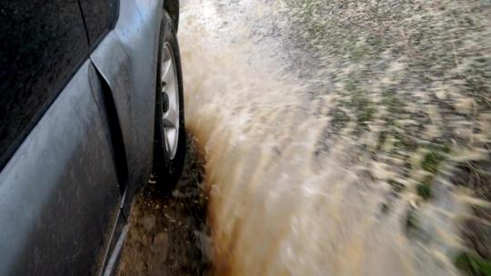 车辆行驶在过水路面溅起水花泥土