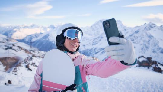 女人站在滑雪场的山顶自拍