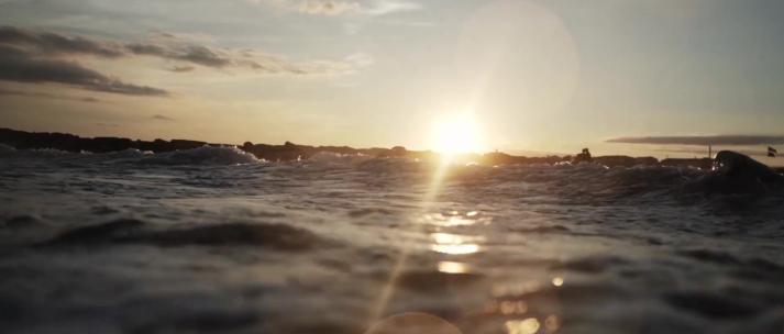 傍晚海面人群玩耍冲浪戏水日落夕阳