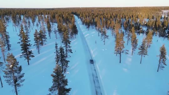 冬季大雪汽车在森林公路上行驶