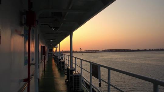 夕阳穿过行驶在大海上的客船