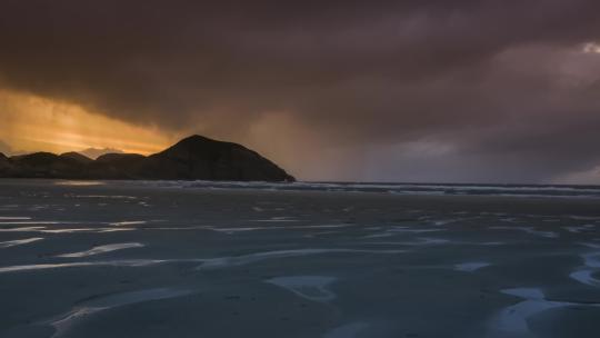 延时摄像日落时海滩上的雨云