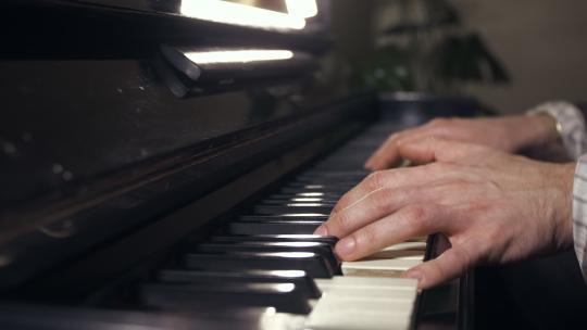 男人手指在钢琴上敲击