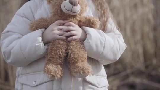 小女孩手中小熊娃娃