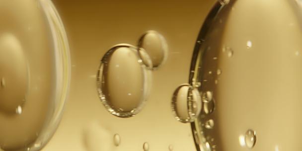 微距拍摄透明水珠水泡在黄色背景下漂浮