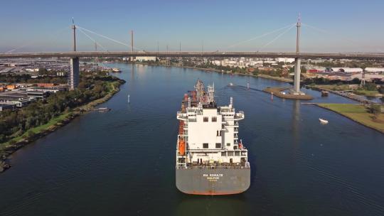 城市航拍万吨货轮穿越大桥缓缓进入港口