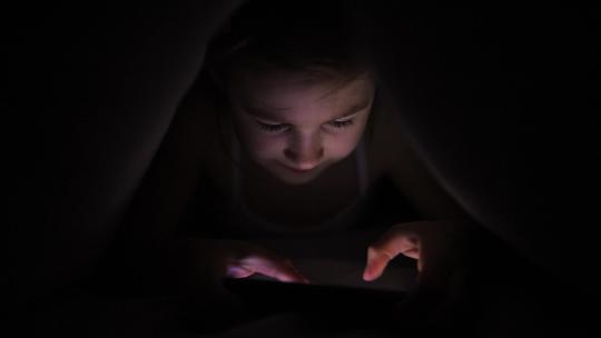 小女孩晚上在手机上玩游戏视频素材模板下载