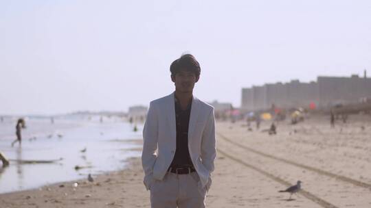 一个穿着正装的男人在海滩上散步