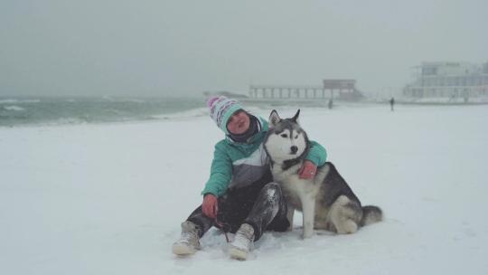 一人一狗坐在雪地上