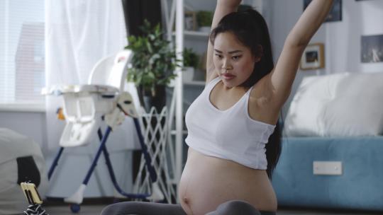 怀孕的美女在健身锻炼身体做瑜伽动作