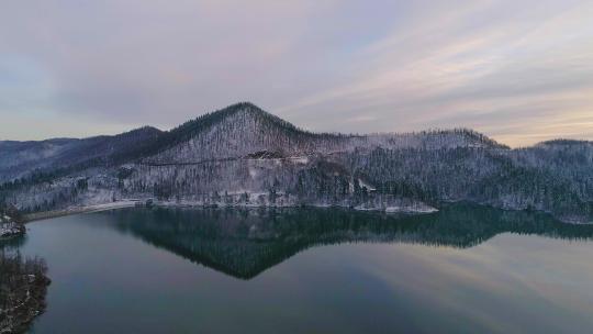 日落时平静冬季湖泊的鸟瞰图