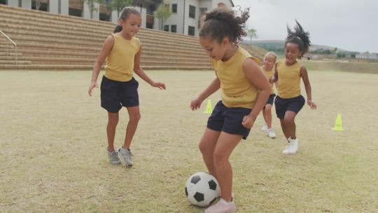 女孩在学校前踢足球视频素材模板下载